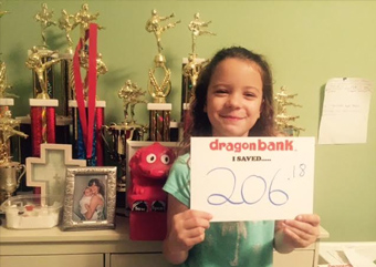 Child holding a sign that says how much they saved with DragonBank